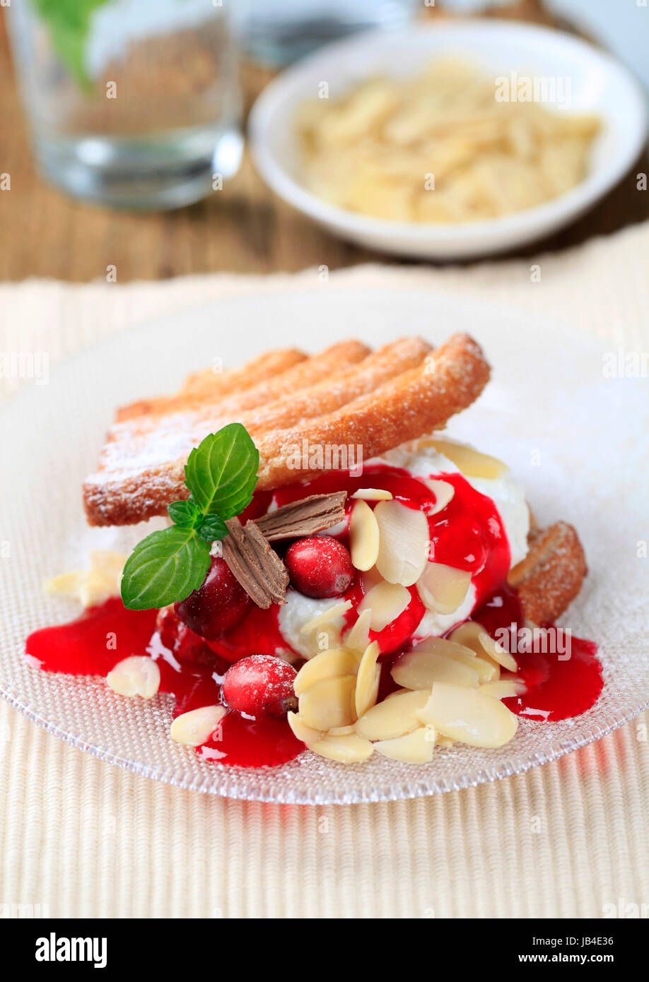 Fan-shaped puff pastries with cream, cranberries and syrup Stock Photo ...
