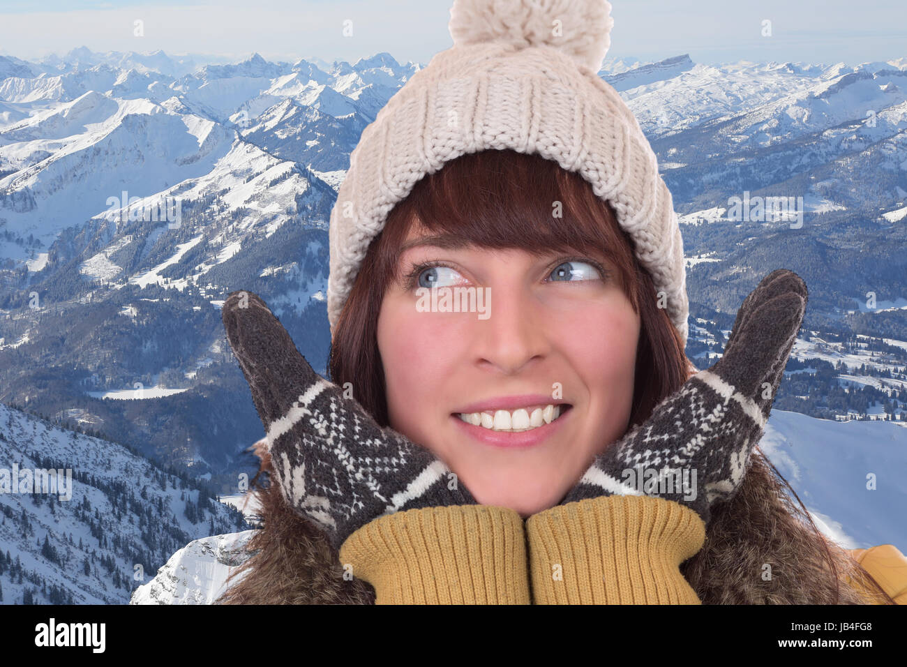 Portrait einer Frau im Winter mit Mütze und Handschuhen in den Bergen Stock Photo