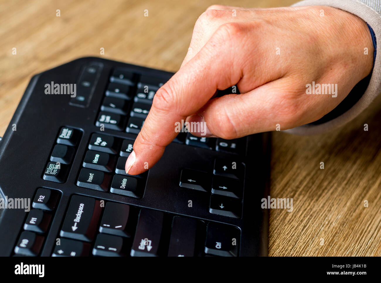 finger about to press the delete button on a keyboard Stock Photo - Alamy