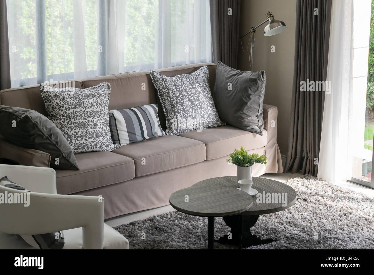 Sturdy brown tweed sofa with grey patterned pillows Stock Photo