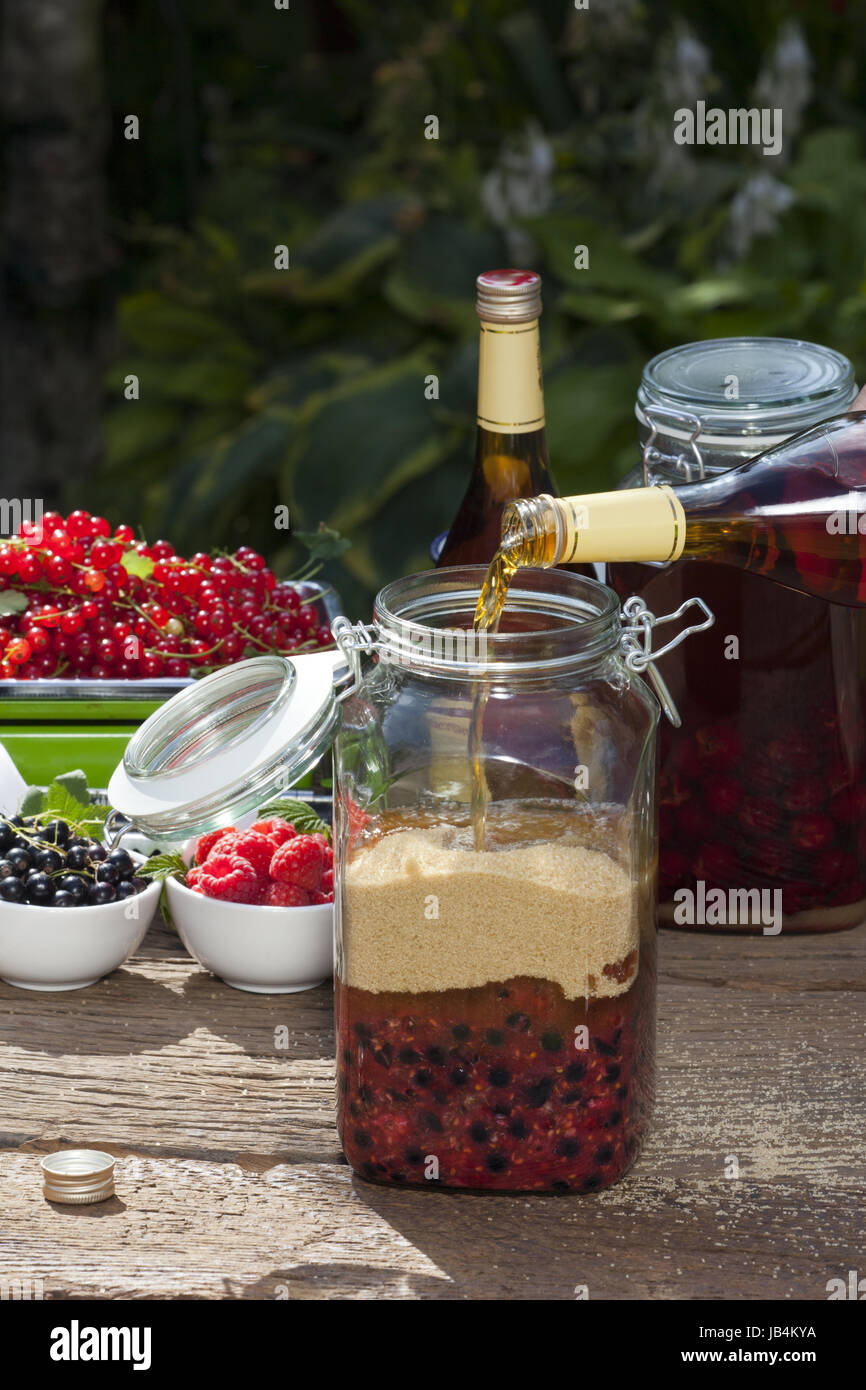 Selber Johannisbeerlikör herstellen, Step 4, Weinbrand in das Glas mit den Früchten und Rohrzucker geben Stock Photo