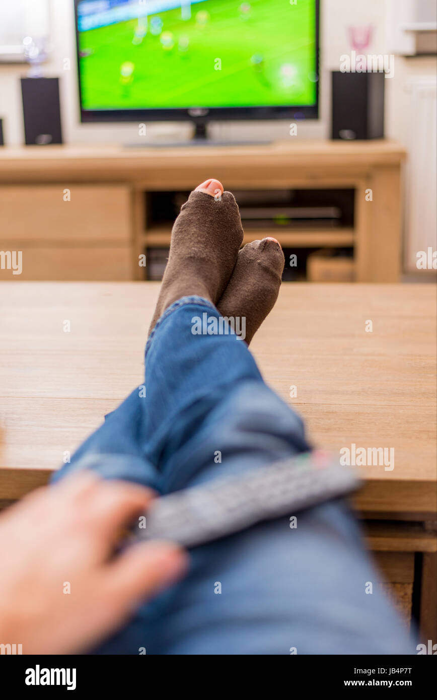 man with holes in his socks watching soccer Stock Photo Alamy