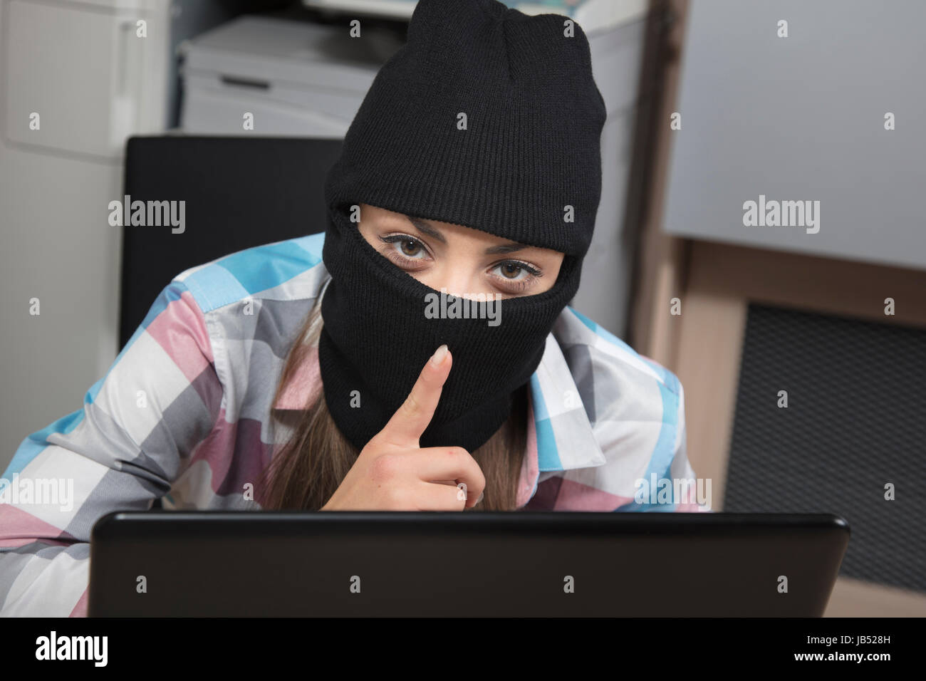 Data thief on computer performs a silent gesture Stock Photo