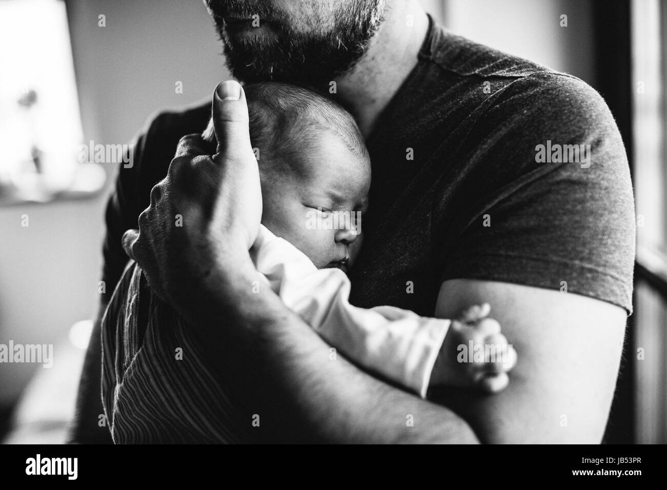 Unrecognizable father at home holding his newborn baby girl. Stock Photo