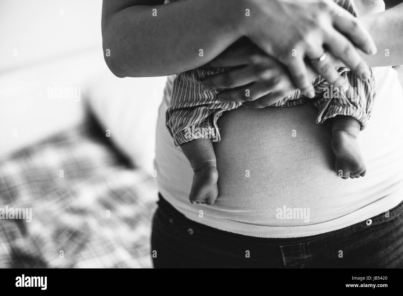 Unrecognizable mother at home holding her newborn baby girl. Stock Photo