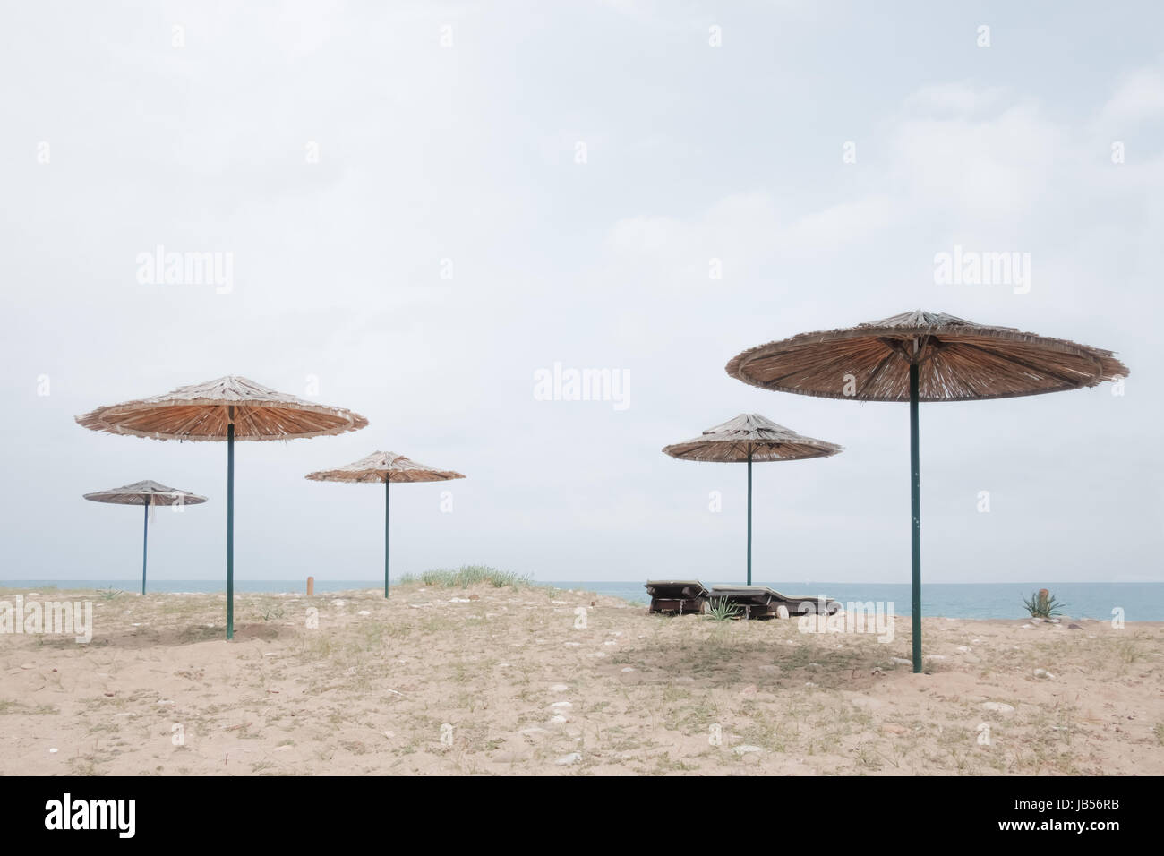 Row of sunshade umbrellas on sea beach. Tranquil view of the Mediterranean sea. Sunny day with clear blue sky. Minimalist scene. Location place: Turke Stock Photo