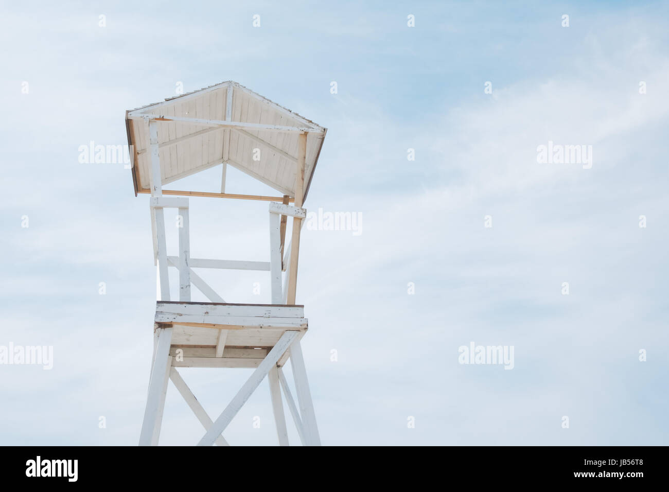 Wooden beach stand on blue sky background ashore of the Mediterranean sea. Sunny day with blue sky and fluffy clouds. Minimalist scene. Location place Stock Photo