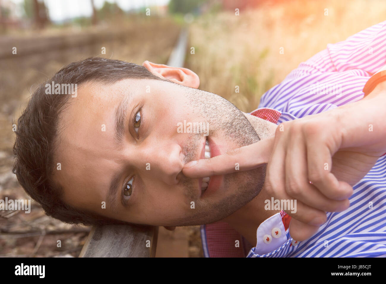 male model possing and lying on the rail Stock Photo