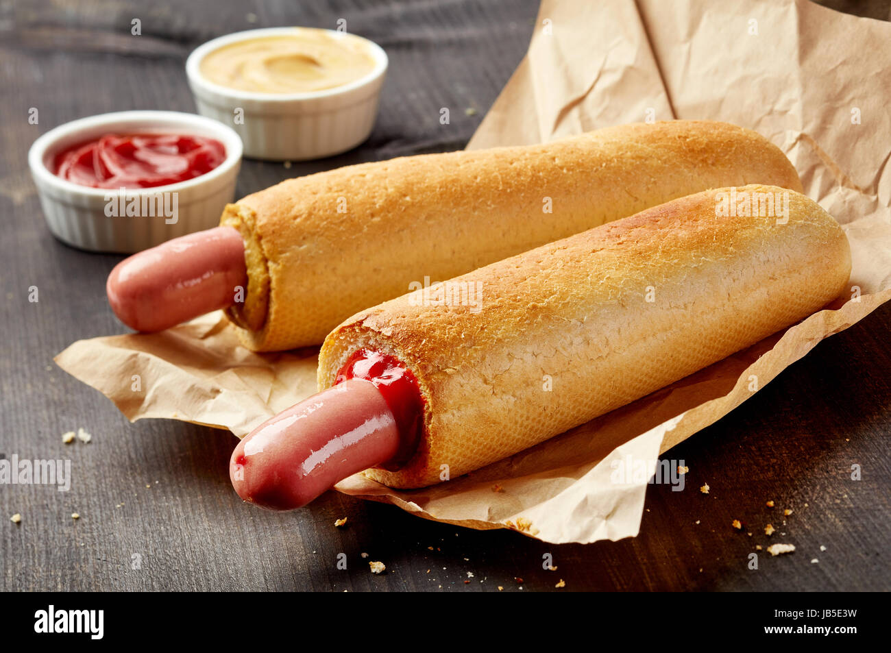 Two hotdogs with mustard and ketchup on wooden table Stock Photo Alamy