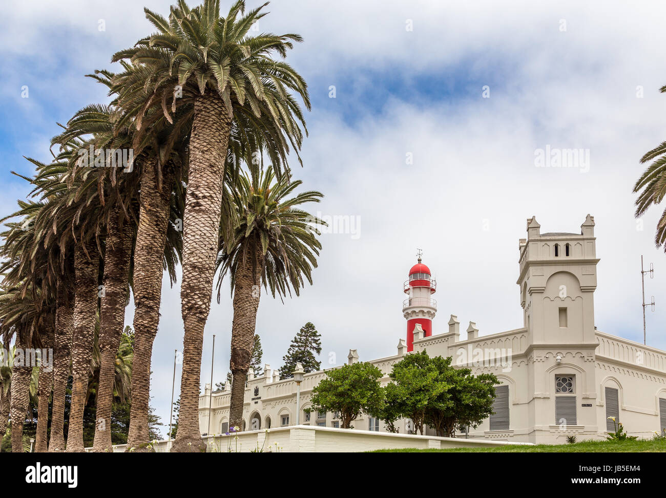 Red lighthouse, white German fort and row of palms, of colonial town of Swakopmund, Namibia Stock Photo