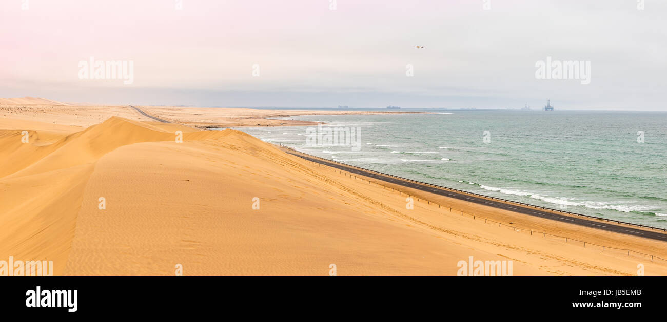 Long road across dunes of Kalahari desert with Atlantic seaside, near to Swakopmund town, Namibia Stock Photo