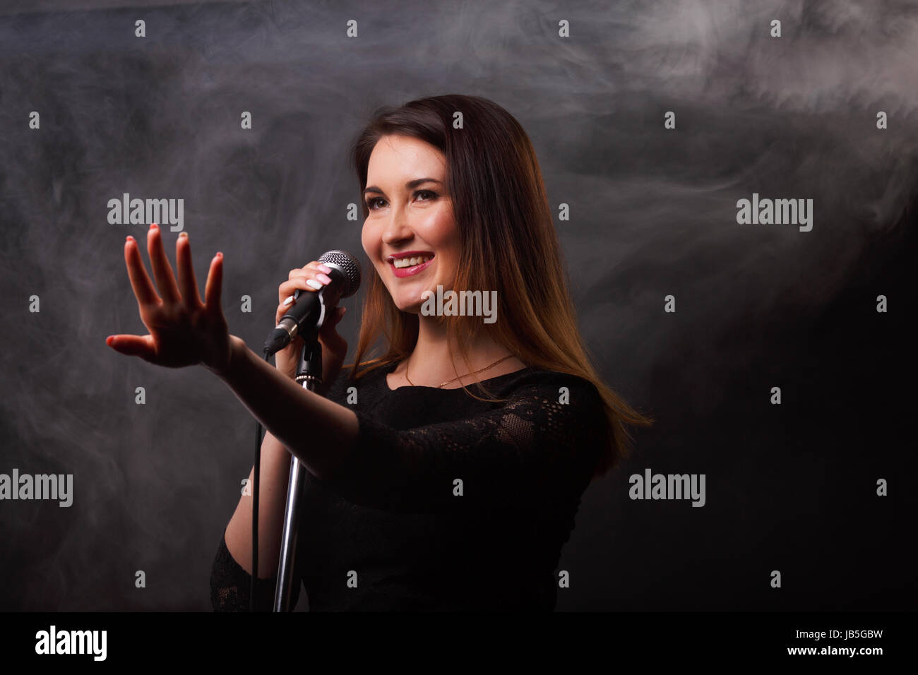 Studio photo of singing brunette Stock Photo - Alamy