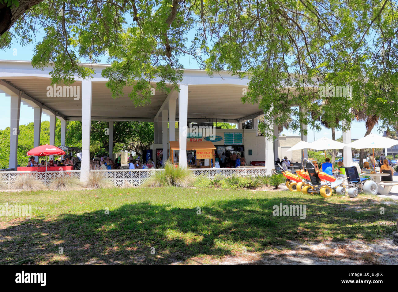 SIESTA KEY, FLORIDA - MAY 9, 2013: Large covered concession stand serving food and beverages with people eating and drinking at shaded tables and seating, beach equipment for rent, restrooms and more. Stock Photo