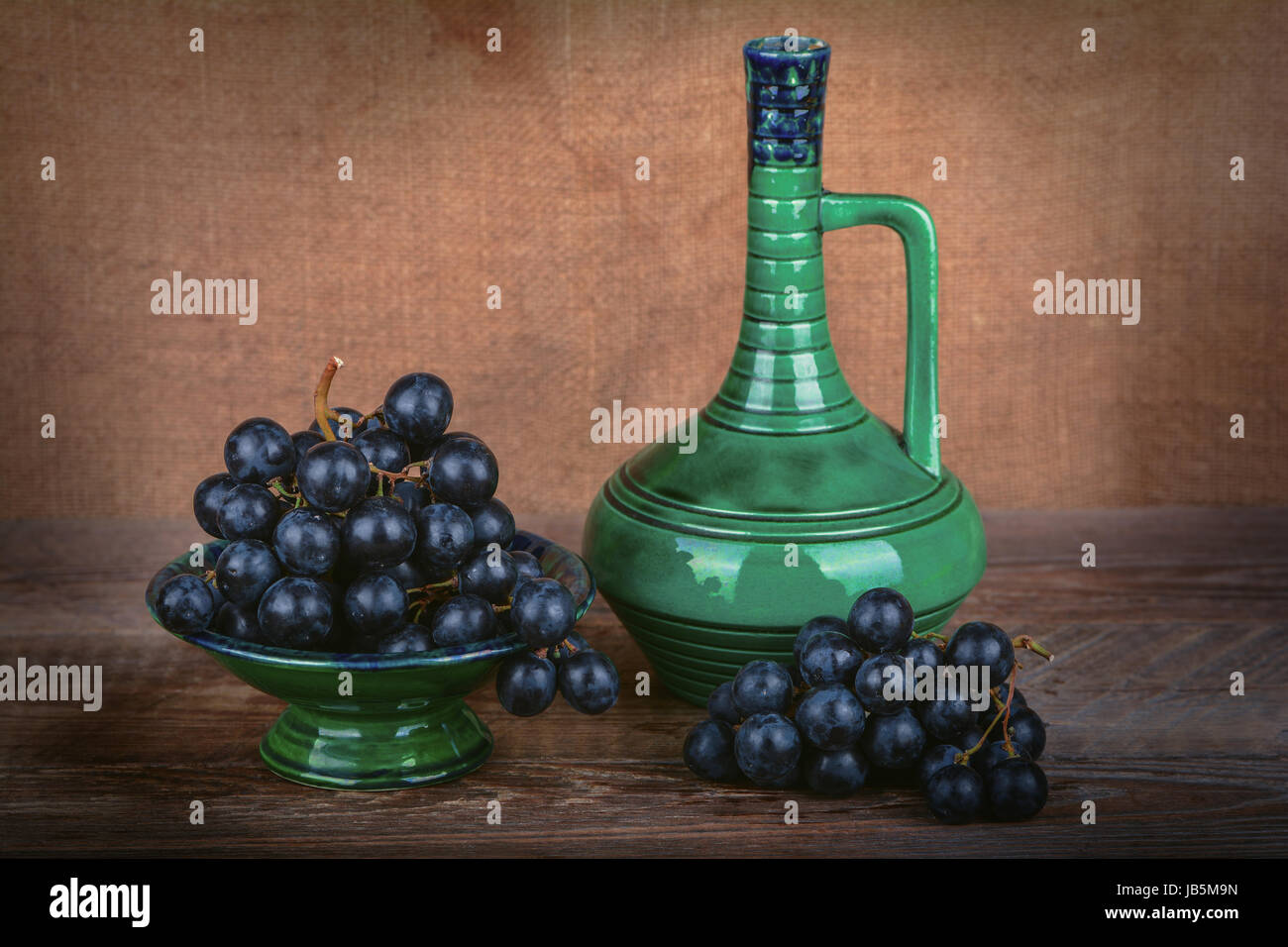 Grapes in a ceramic vase, a jug of wine Stock Photo Alamy
