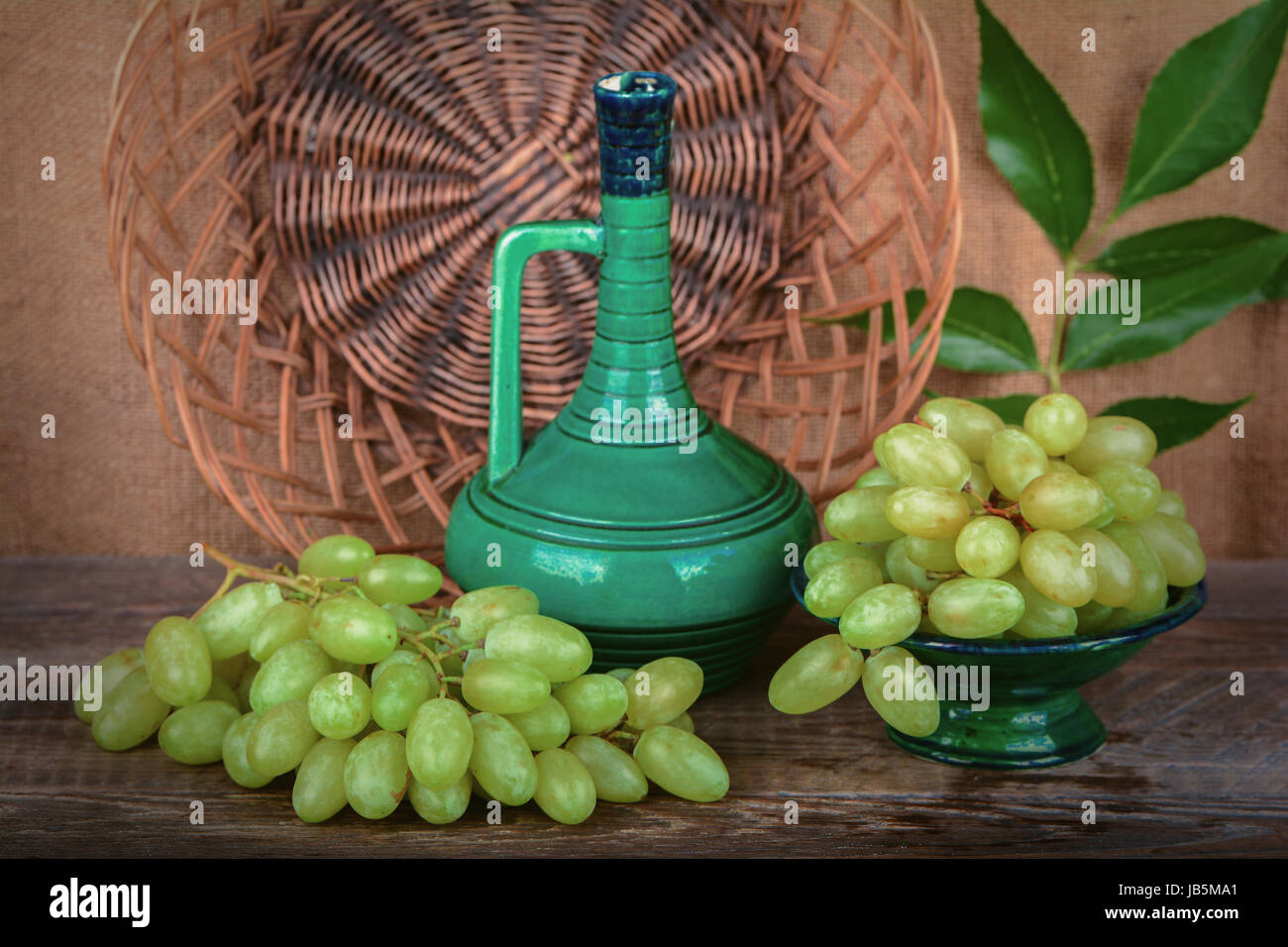Grapes in a ceramic vase, a jug of wine Stock Photo Alamy