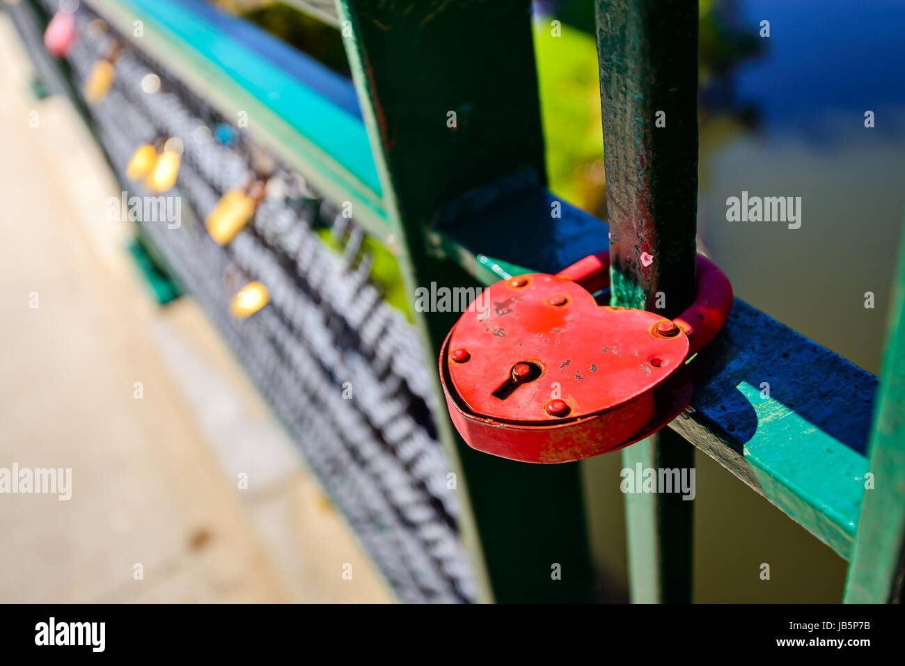 Vintage red love lock hanging on the fence as a symbol of loyalty and eternal love Stock Photo