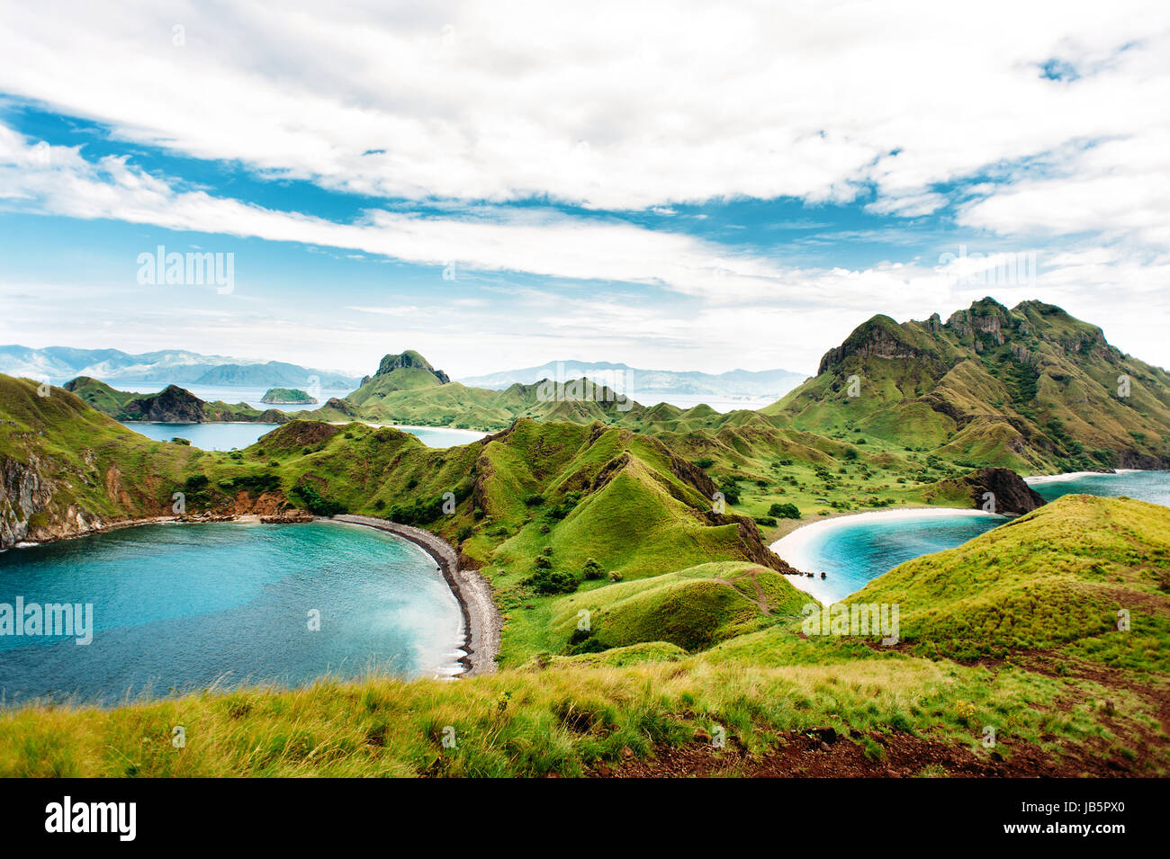 Padar Island, Komodo National Park in East Nusa Tenggara, Indonesia. Amazing marine seascape with mountains and rocks. Blue sky with clouds. Stock Photo