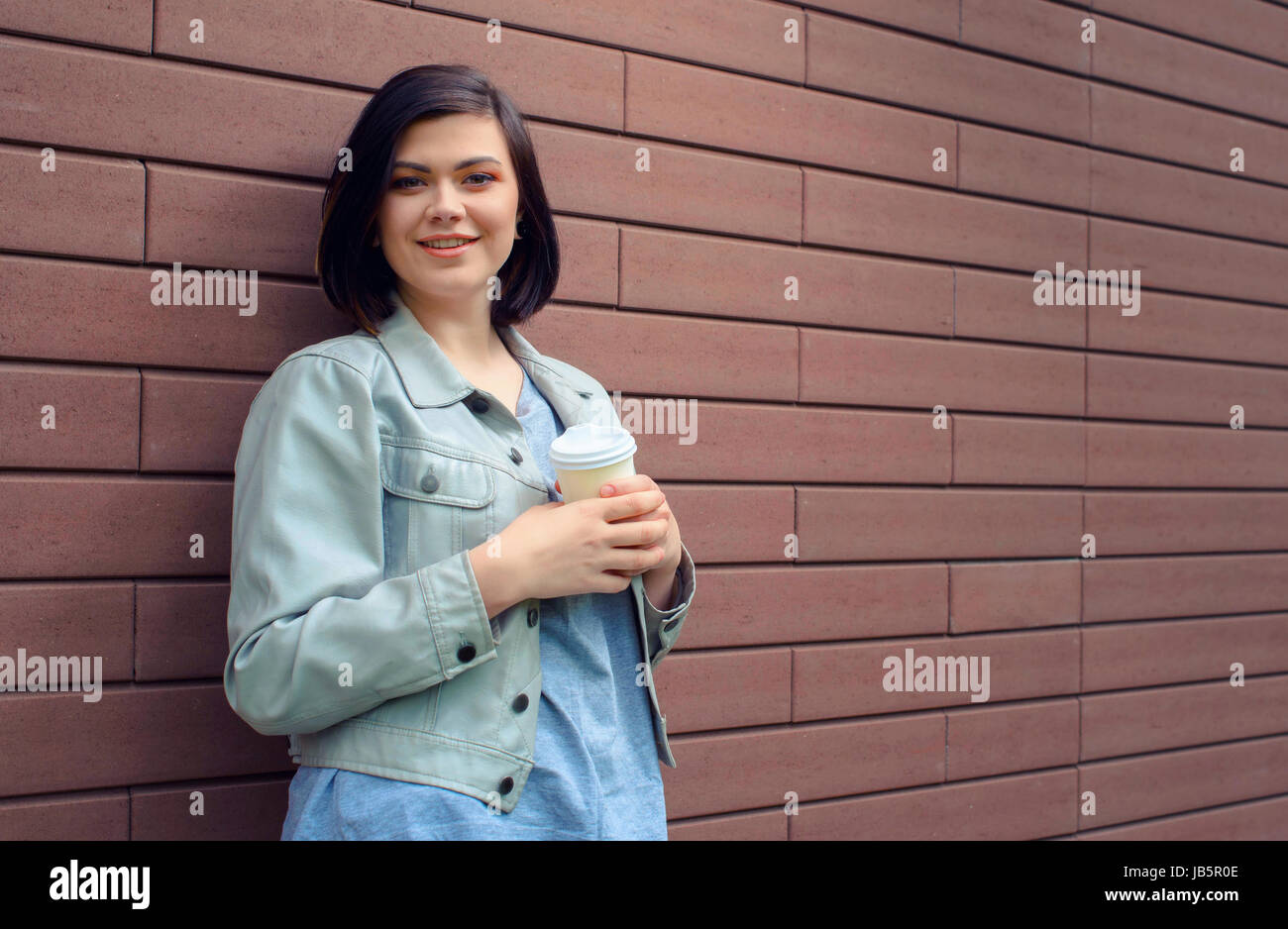 Attractive young woman with tunnels in the ears in a beige