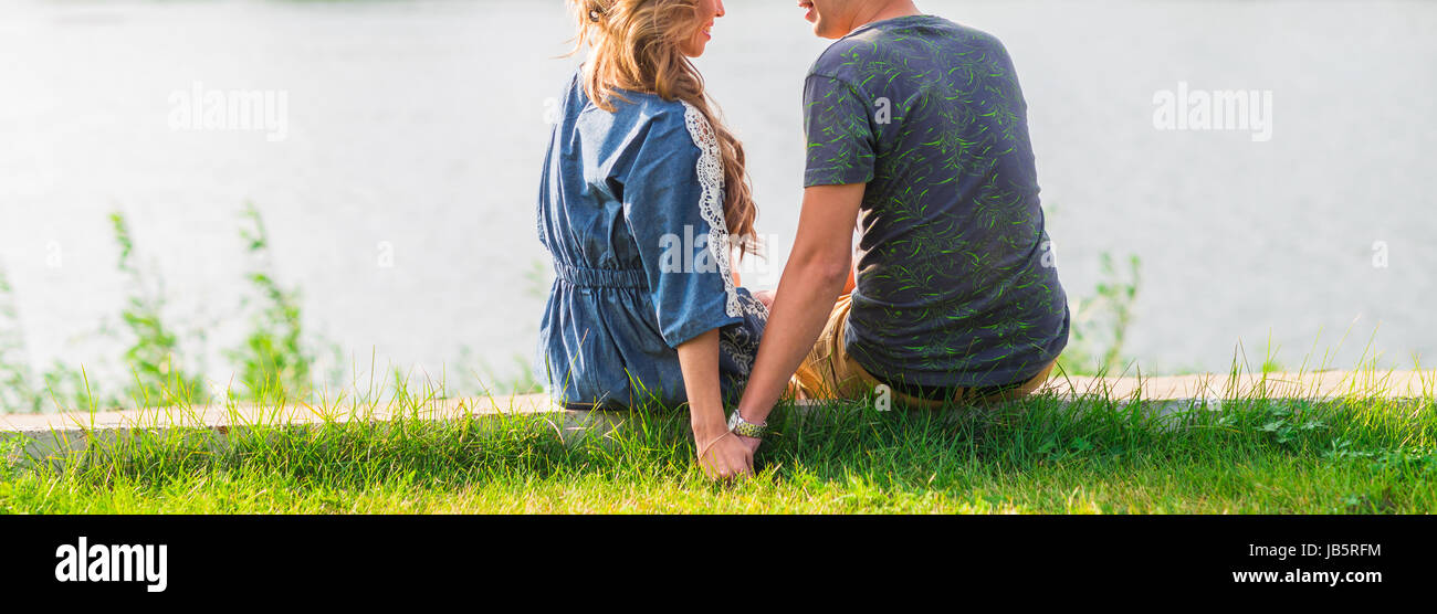 A young couple is romantic in the park on a lake. Man and woman sit in ...