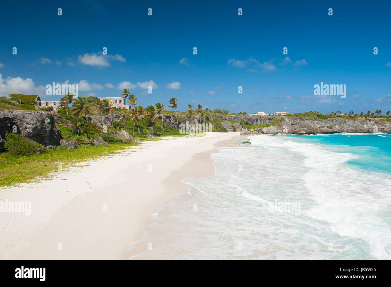 Harrismith Beach is one of the most beautiful beaches on the Caribbean island of Barbados. It is a tropical paradise with palms hanging over turquoise sea and a ruin of an old mansion on the cliff Stock Photo