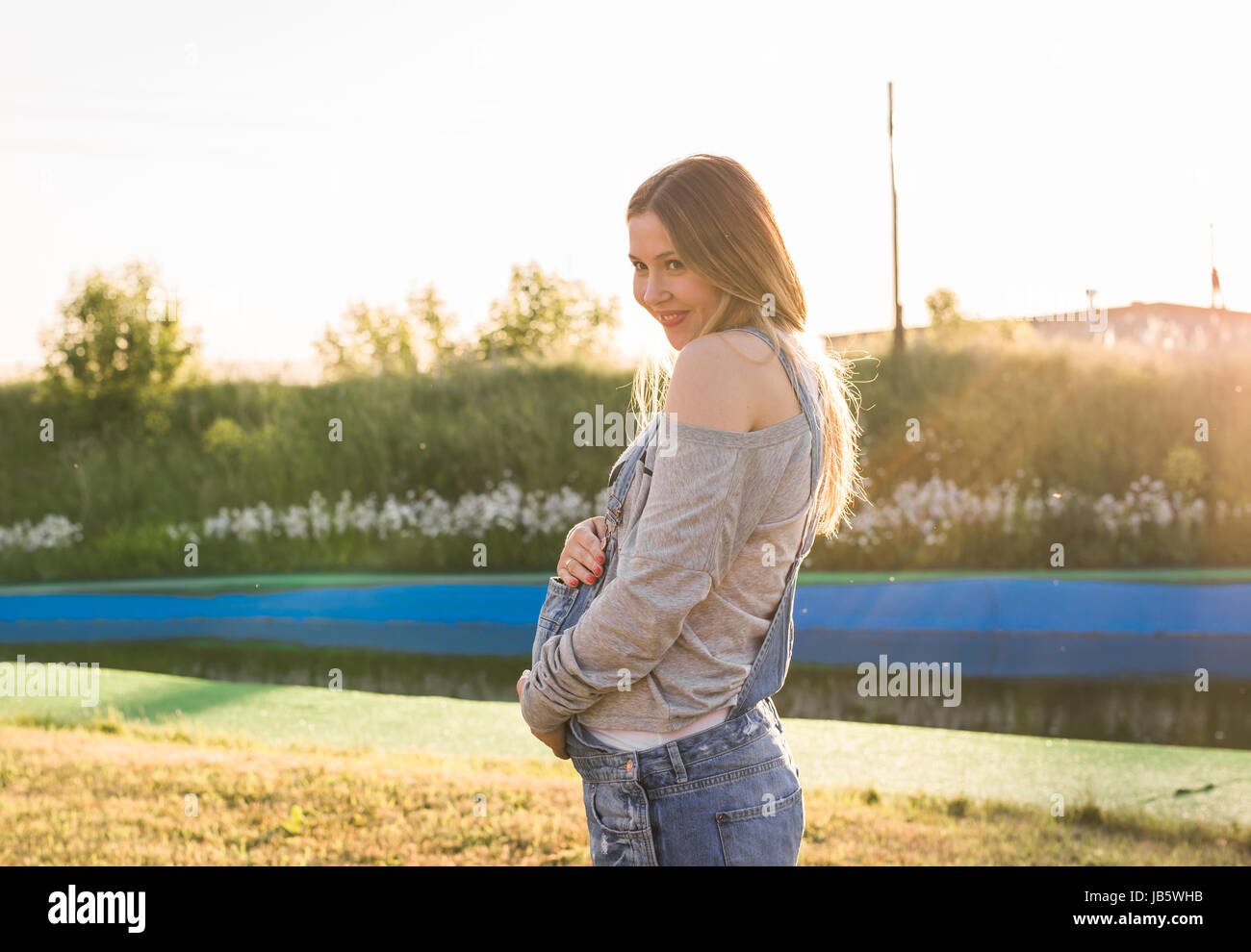 Pregnant young woman hugging her stomach outdoors Stock Photo - Alamy
