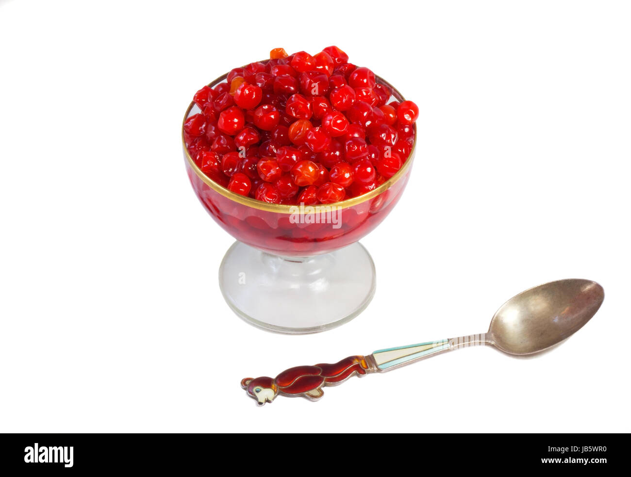 Bright red berries in a crystal vase filled with sugar syrup. Presented on a white background. Stock Photo