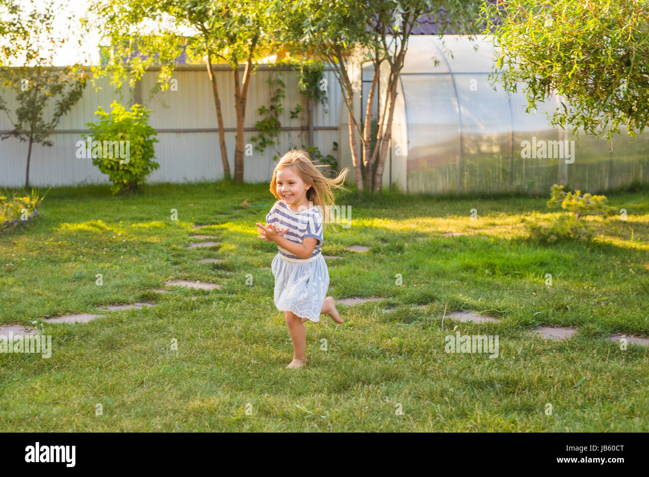 Cute little girl is playing in summer park Stock Photo - Alamy