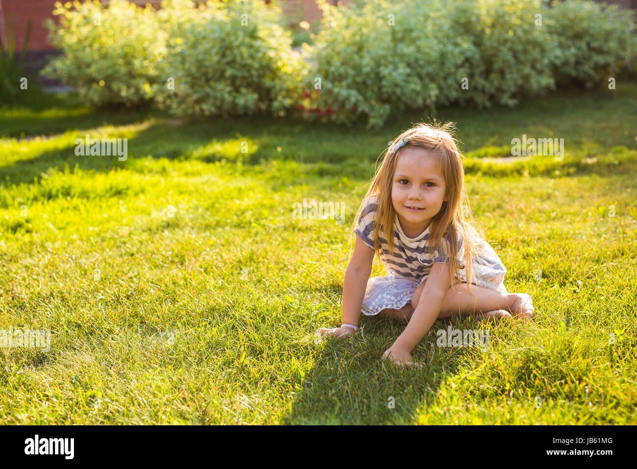 Cute little girl is playing in summer park Stock Photo - Alamy