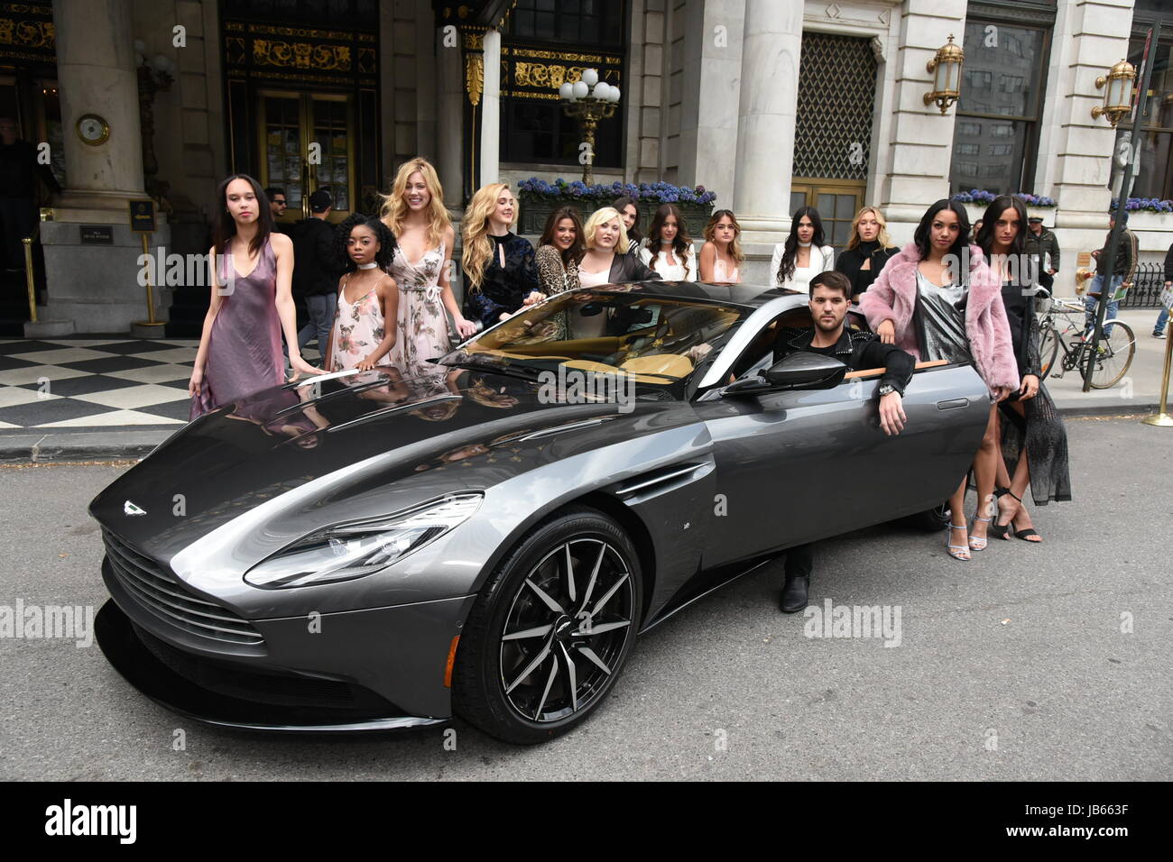 Andrew Warren surrounded by his models as he poses by an Aston Martin ...