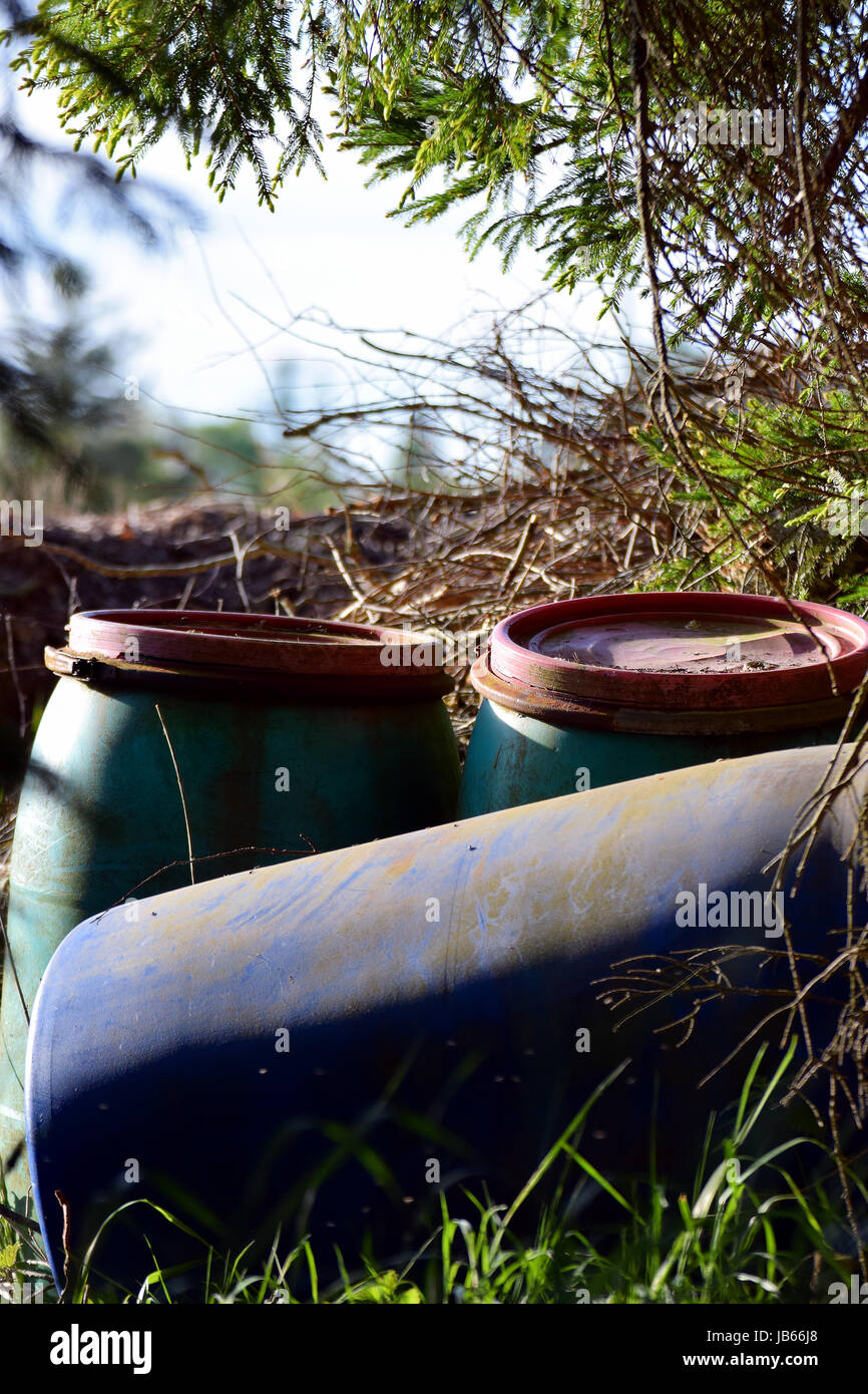 Old plastic barrels left in nature. Vertical image Stock Photo