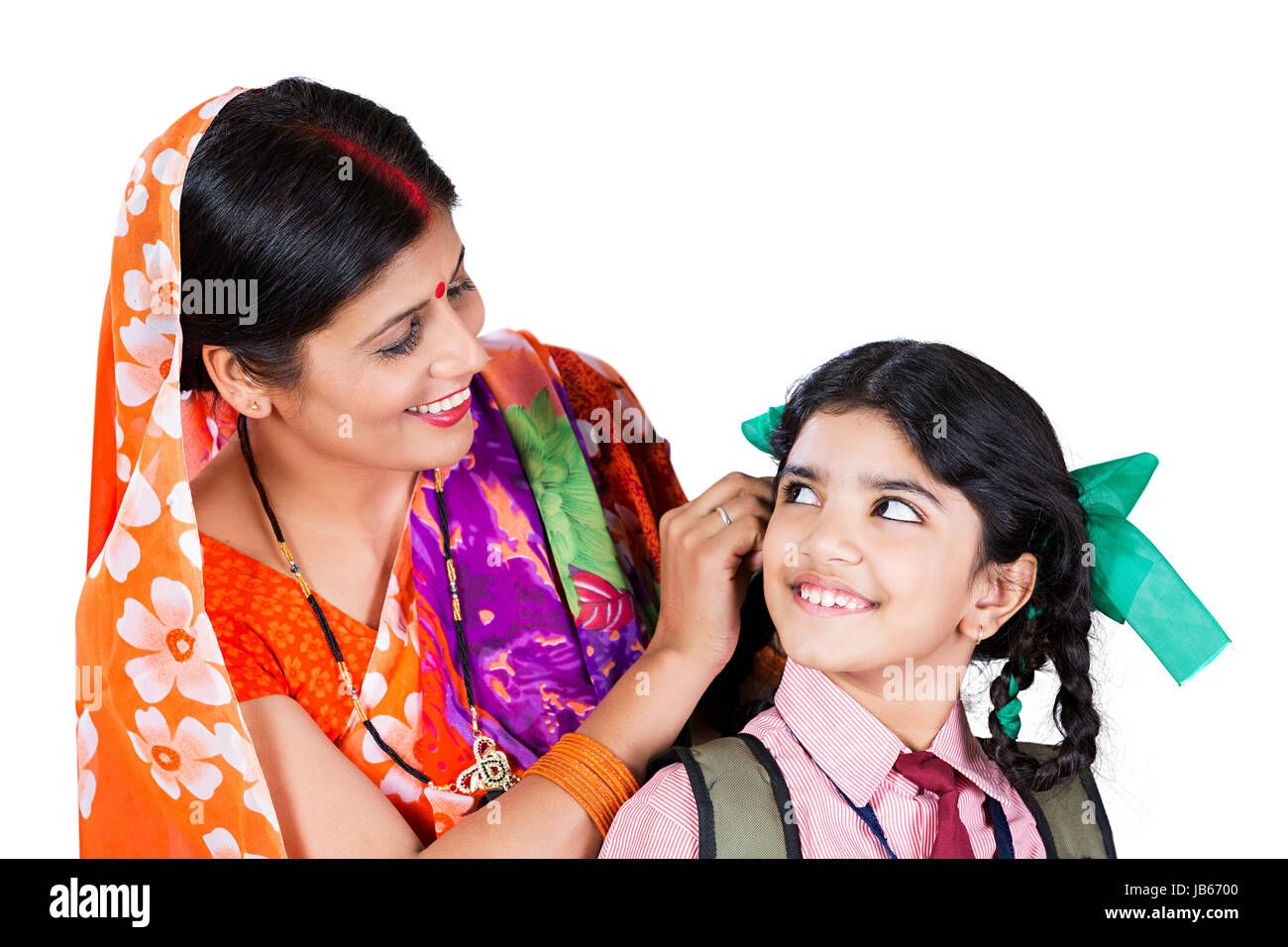 Indian Rural mother getting Kid Daughter ready for school Stock Photo
