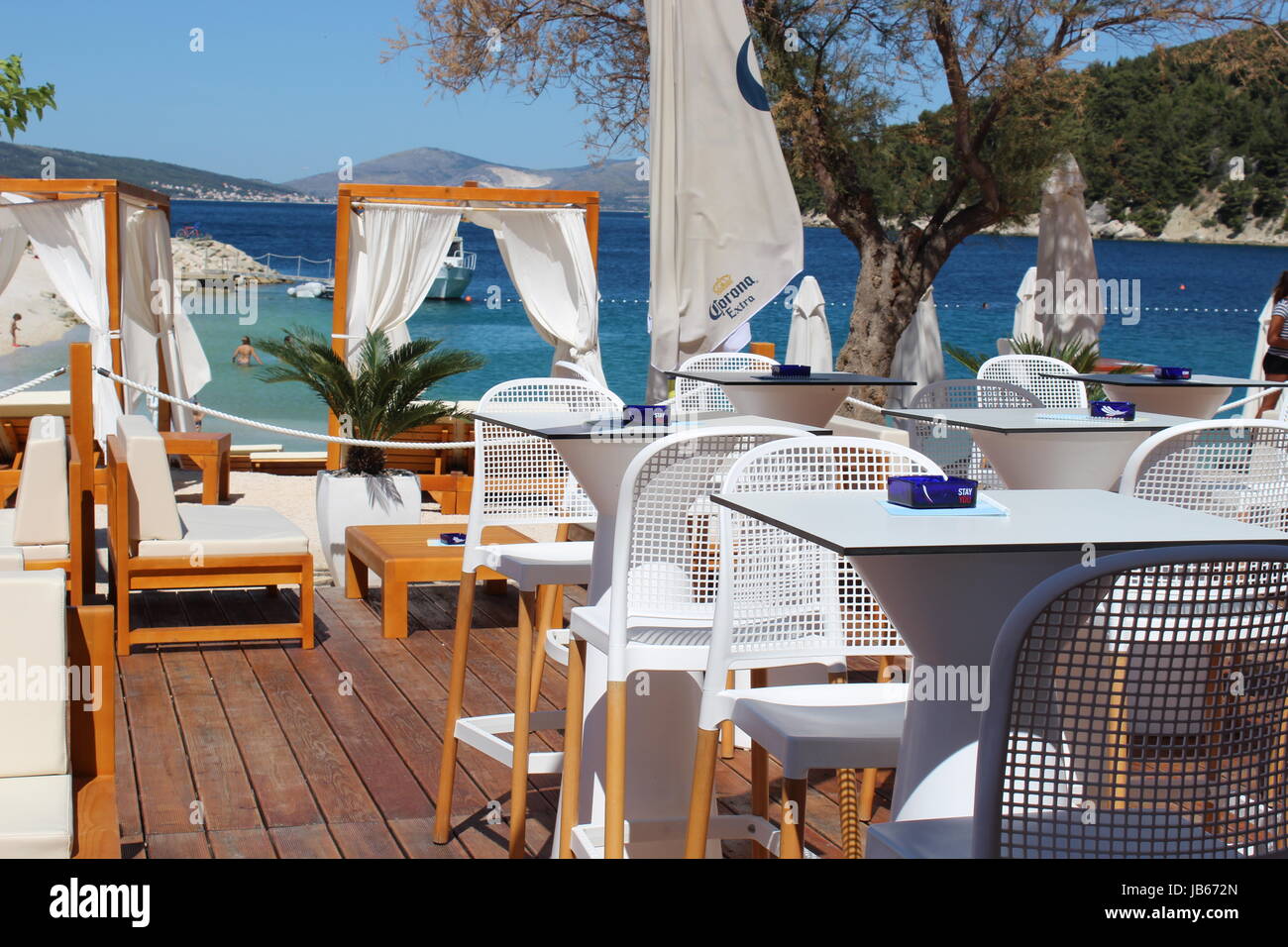 Idyllic beachside restaurant with white tables and canopies in Marjan near Split, Croatia Stock Photo