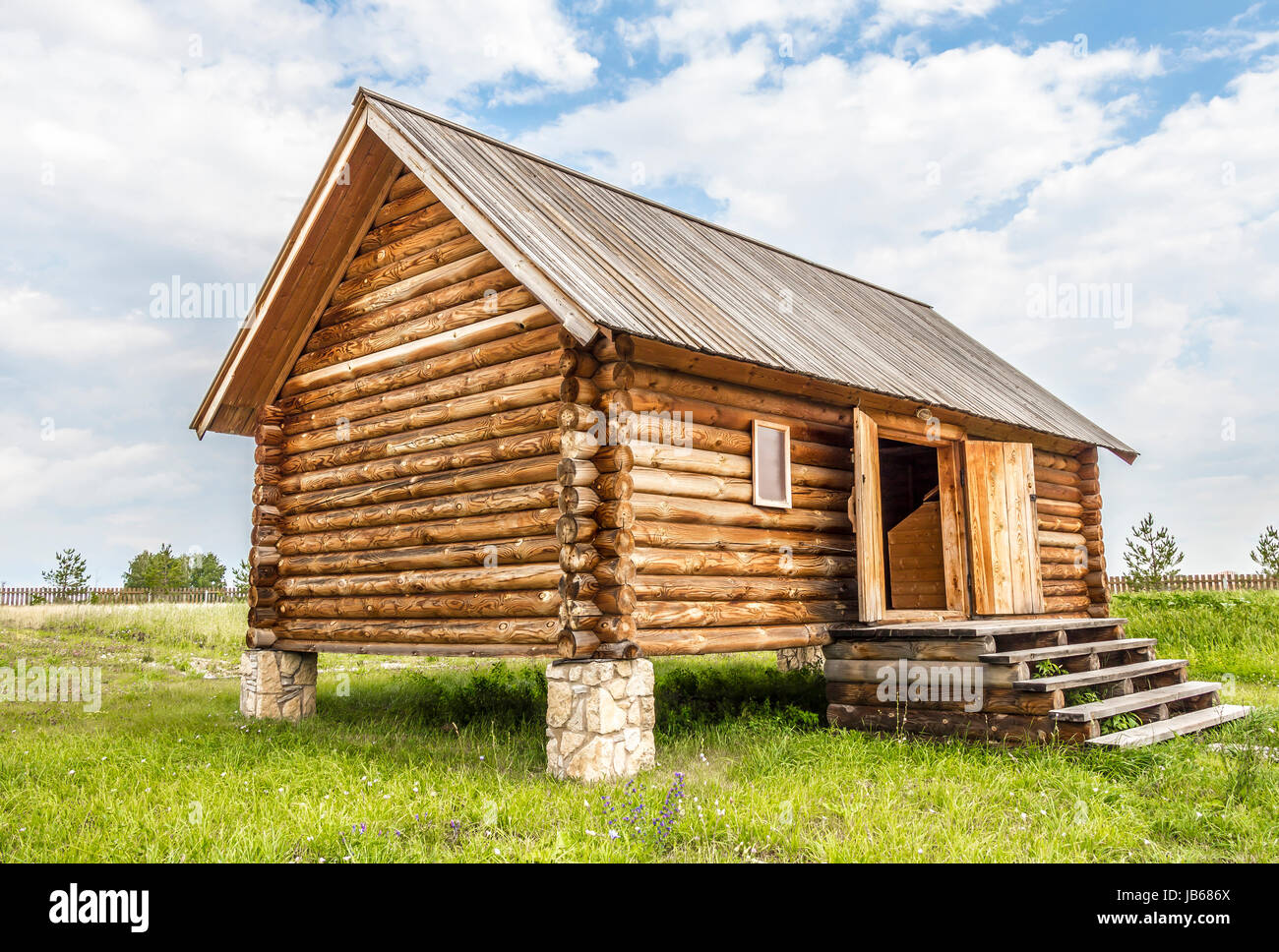 Rustic Wooden Log House On The Posts As The Foundation Stock Photo