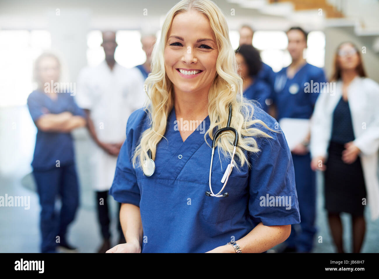 Young female medical professional standing with the stethoscope in a clinic. Team of doctors at hospital Stock Photo