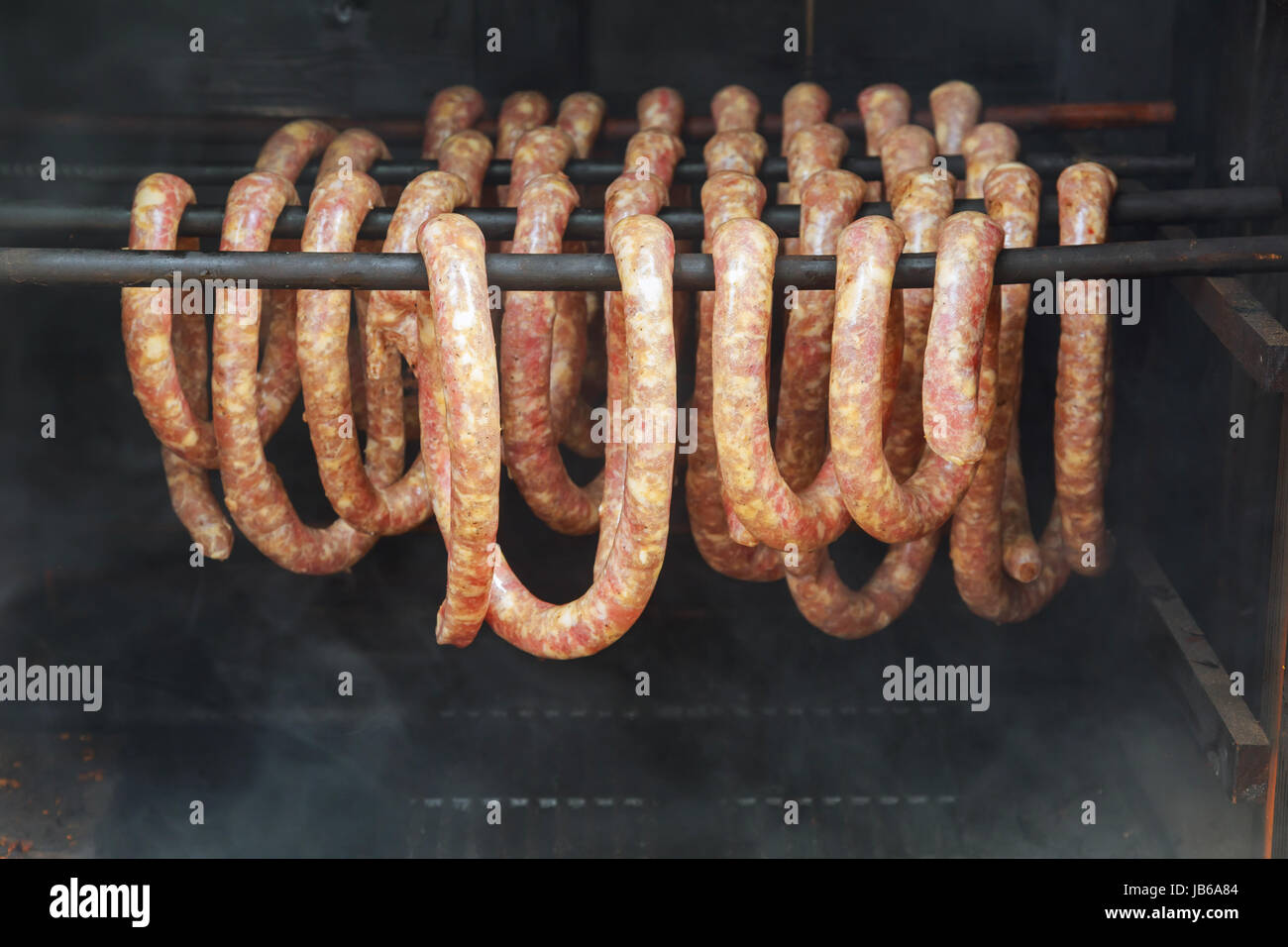 Smoked sausages hanging in smokehouse, smoked sausages in traditional