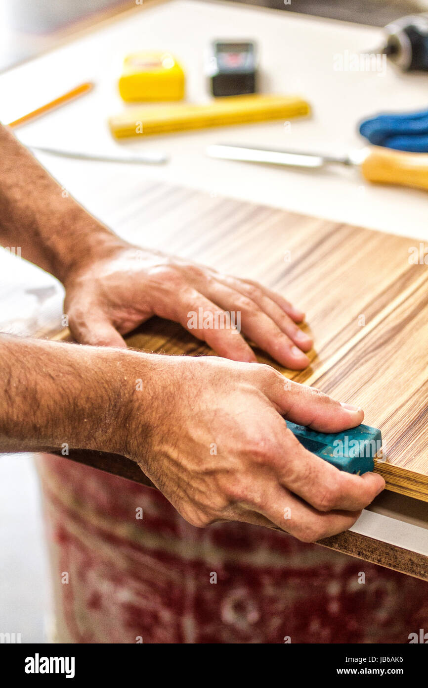 Hands of a joiner working on the finishing of a MDF timber in a joinery. Palhoca, Santa Catarina, Brazil. Stock Photo