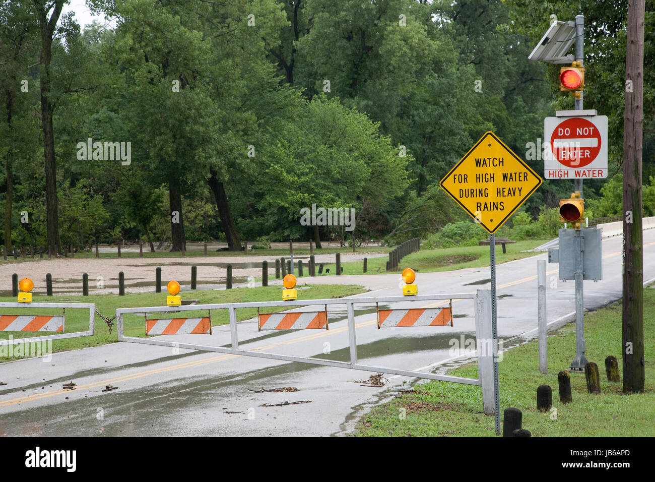 High Water Flood Signs and Road Flood Gate Stock Photo