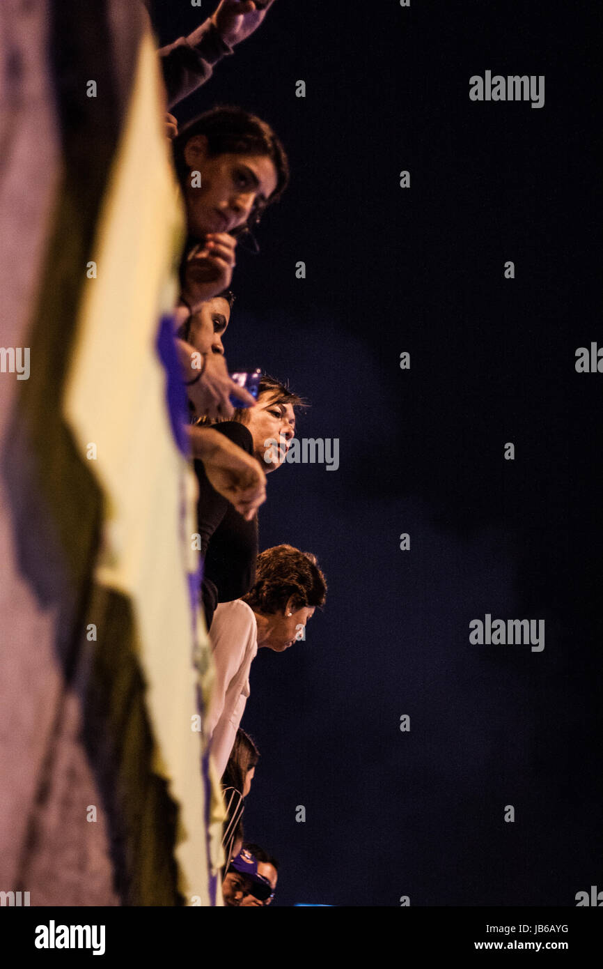 A group of persons stand on a street during a vigil for Neomar Lander, a teenager who died during a protest against the government of Nicolas Maduro. Stock Photo