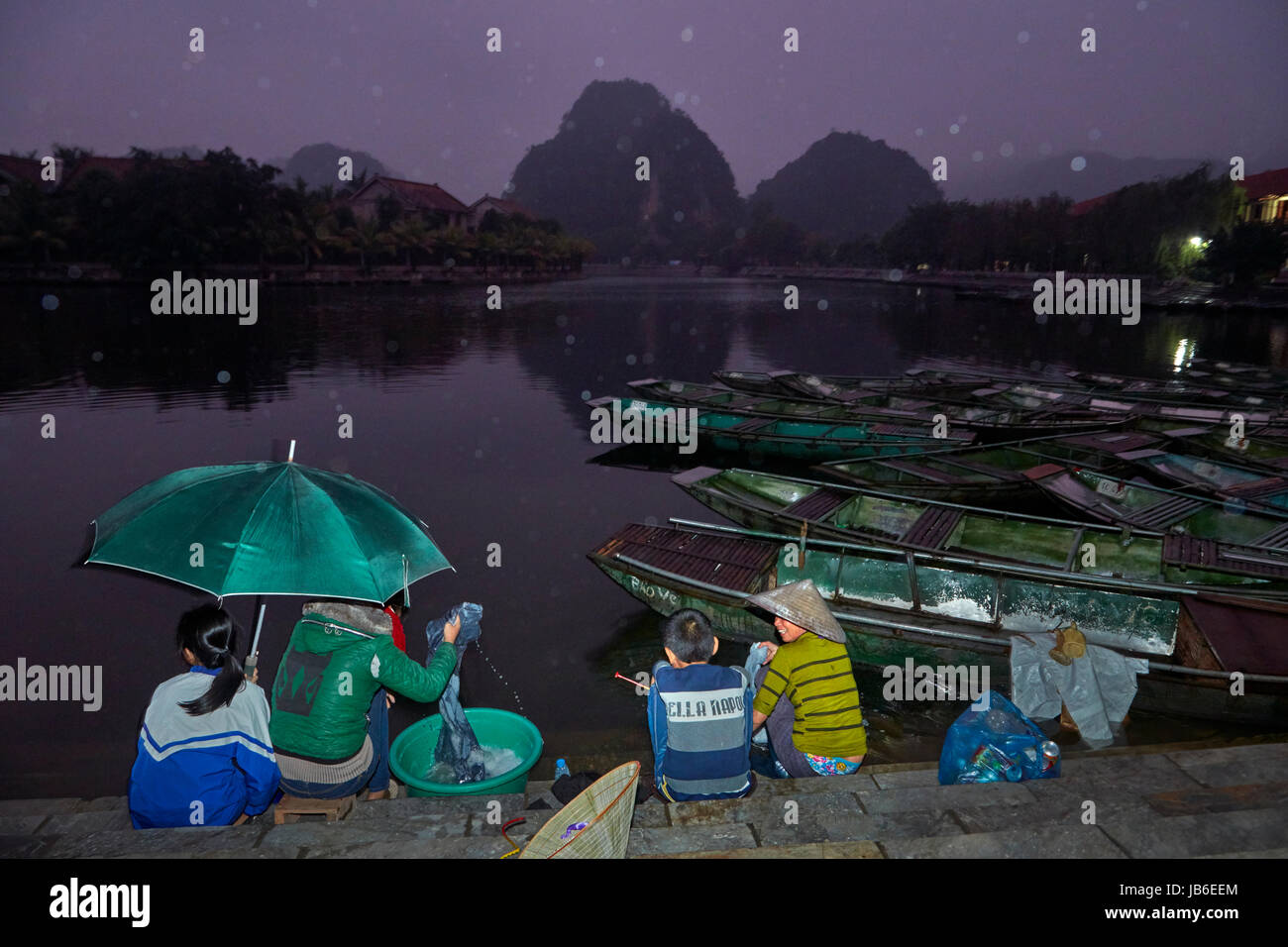 Rain at dusk at Ninh Hai boat harbour for Tam Coc boat trips through limestone caves and karsts, Ninh Binh, Vietnam Stock Photo