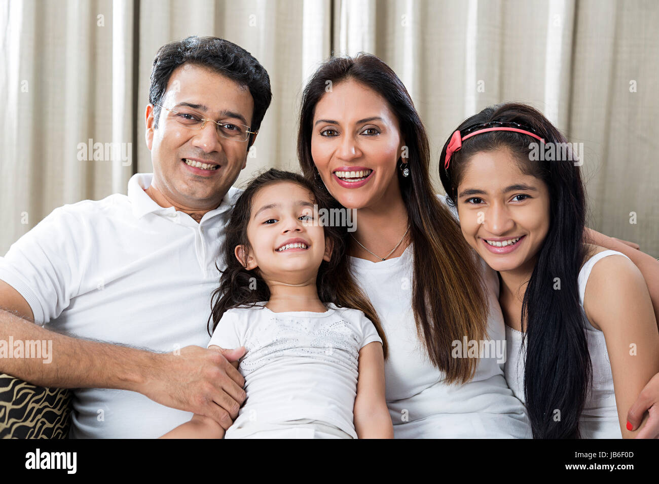 4 People At Home Daughter Father Girls Mother Sitting Smiling Sofa Togetherness Stock Photo