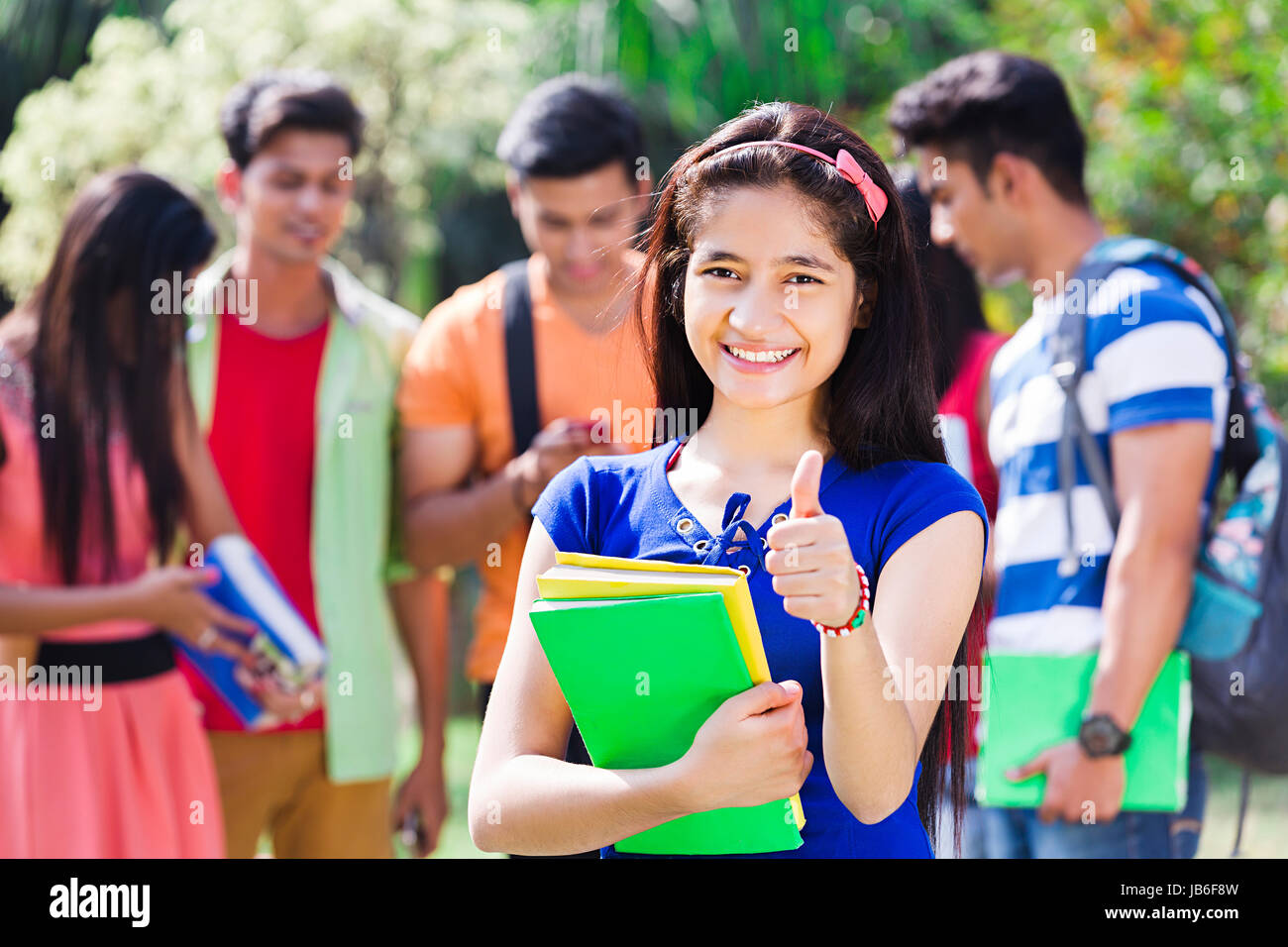 1 Indian College Girl Student Standing In Park Showing Thumsb up Stock Photo