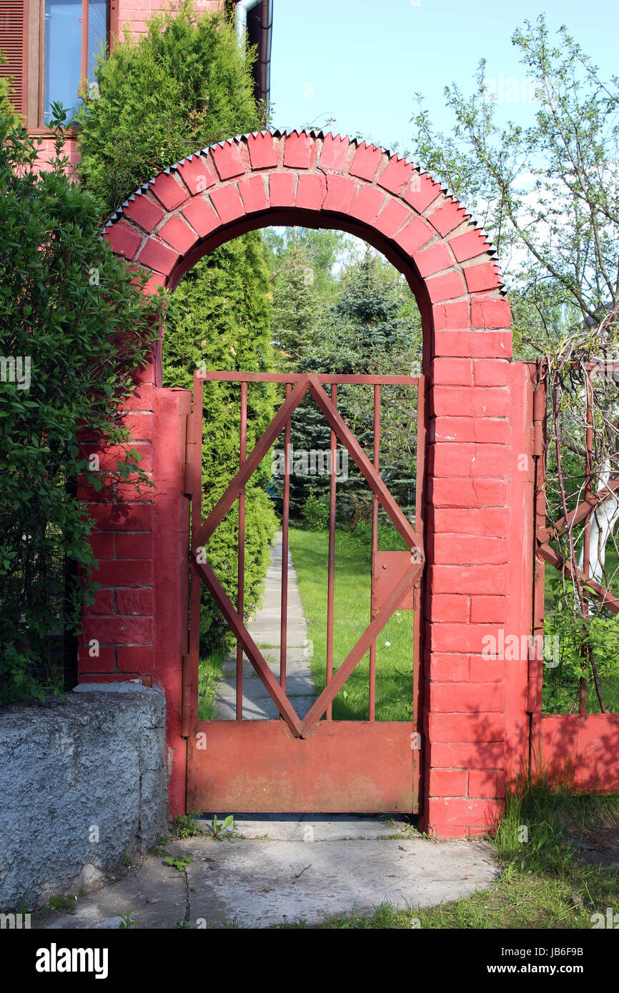 Garden gate with a decorative brick arch. Brick archway entrance Stock Photo