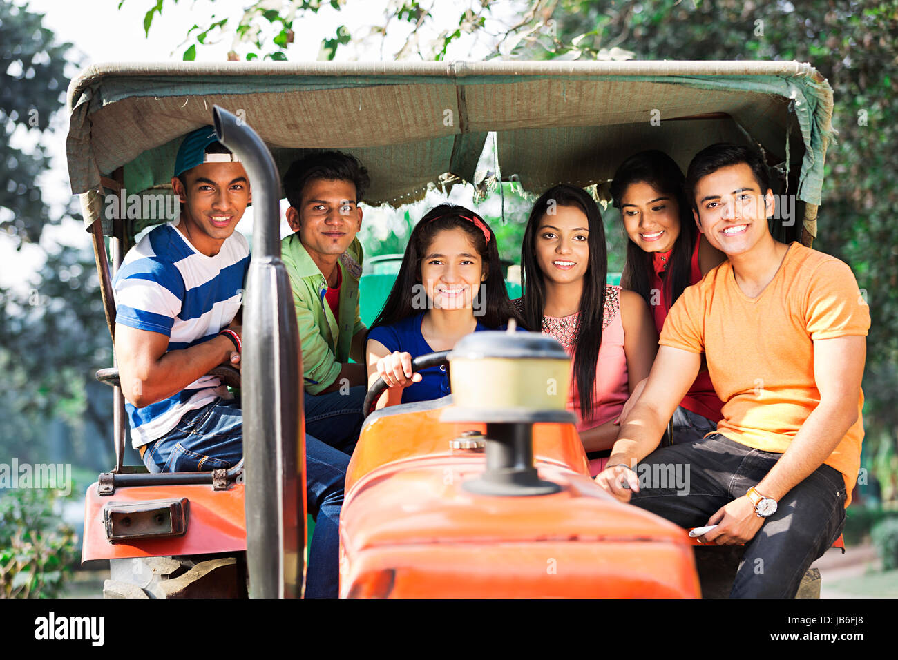 Happy Group Teenagers Boys And Girls Friends Ride s Tractor Enjoying Vacations And Holidays Stock Photo