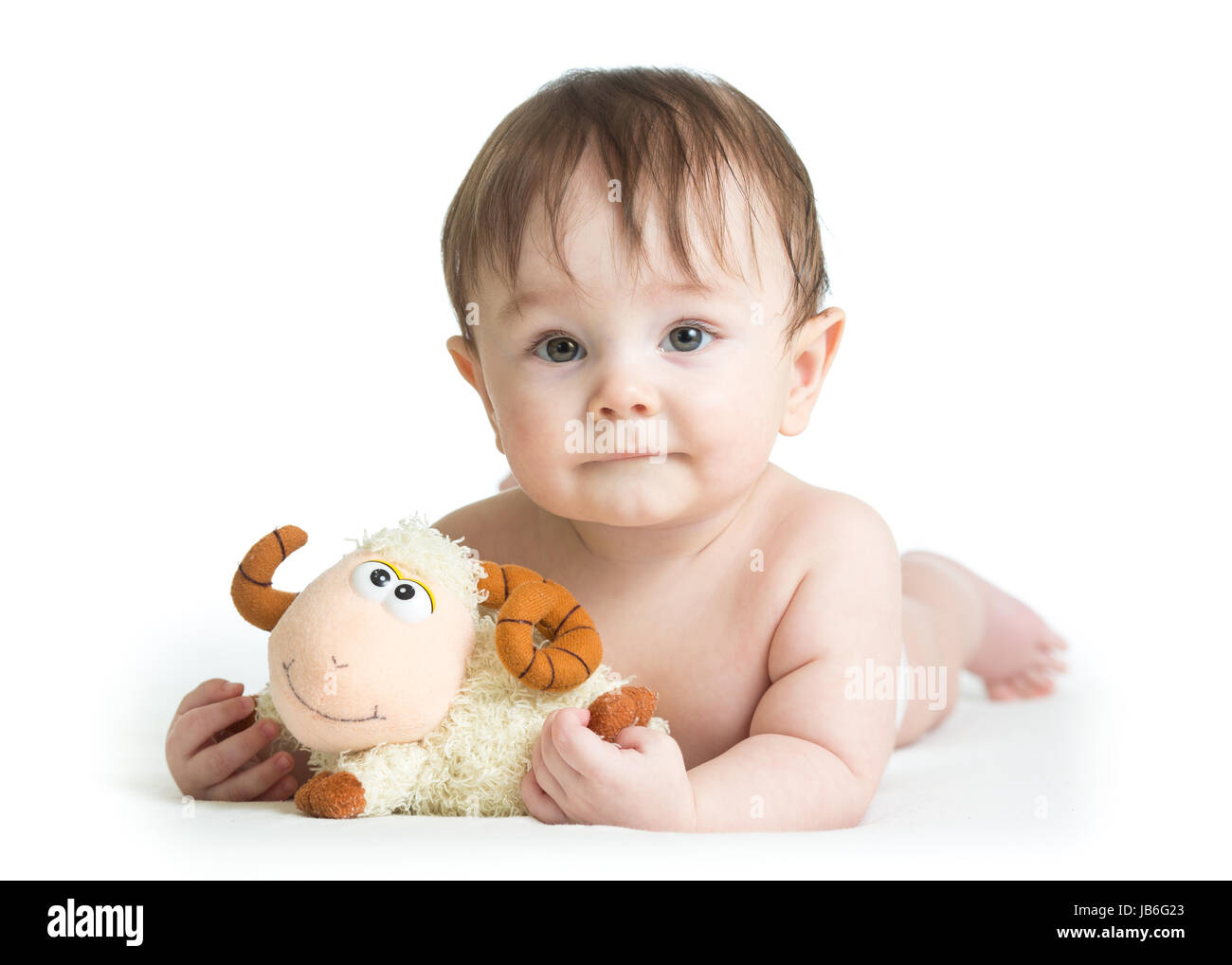baby boy lying on tummy with lamb toy Stock Photo