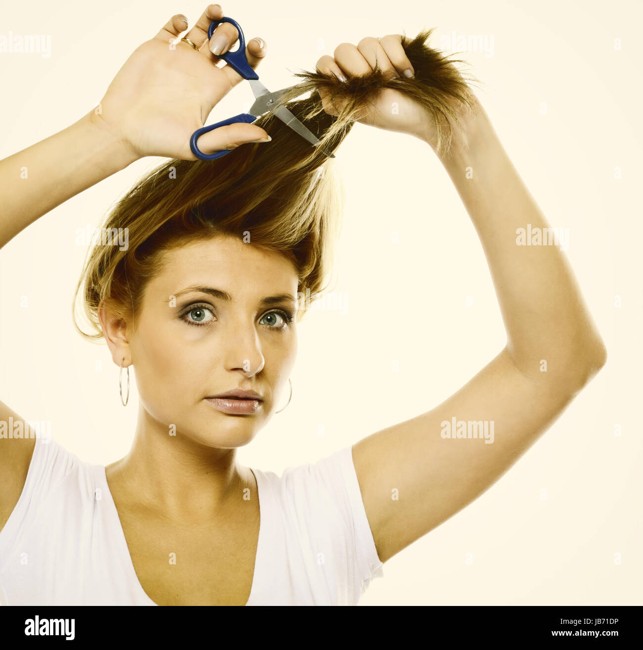 Damaged dry hair splitting ends. Young blonde woman cutting her hair