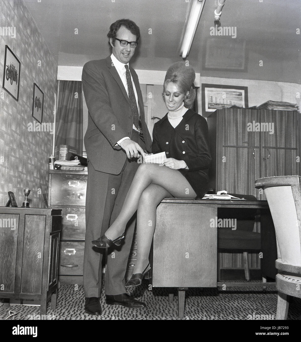 1970s Historical A Secretary Wearing A Mini Skirt Sits On The Edge Of 