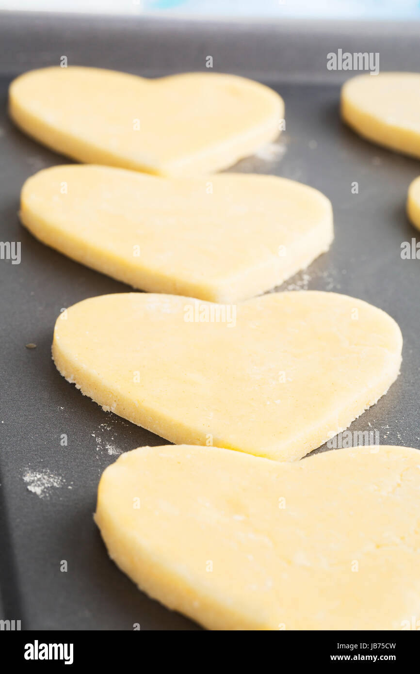 Heart shaped cookies on baking sheet ready for baking. Stock Photo