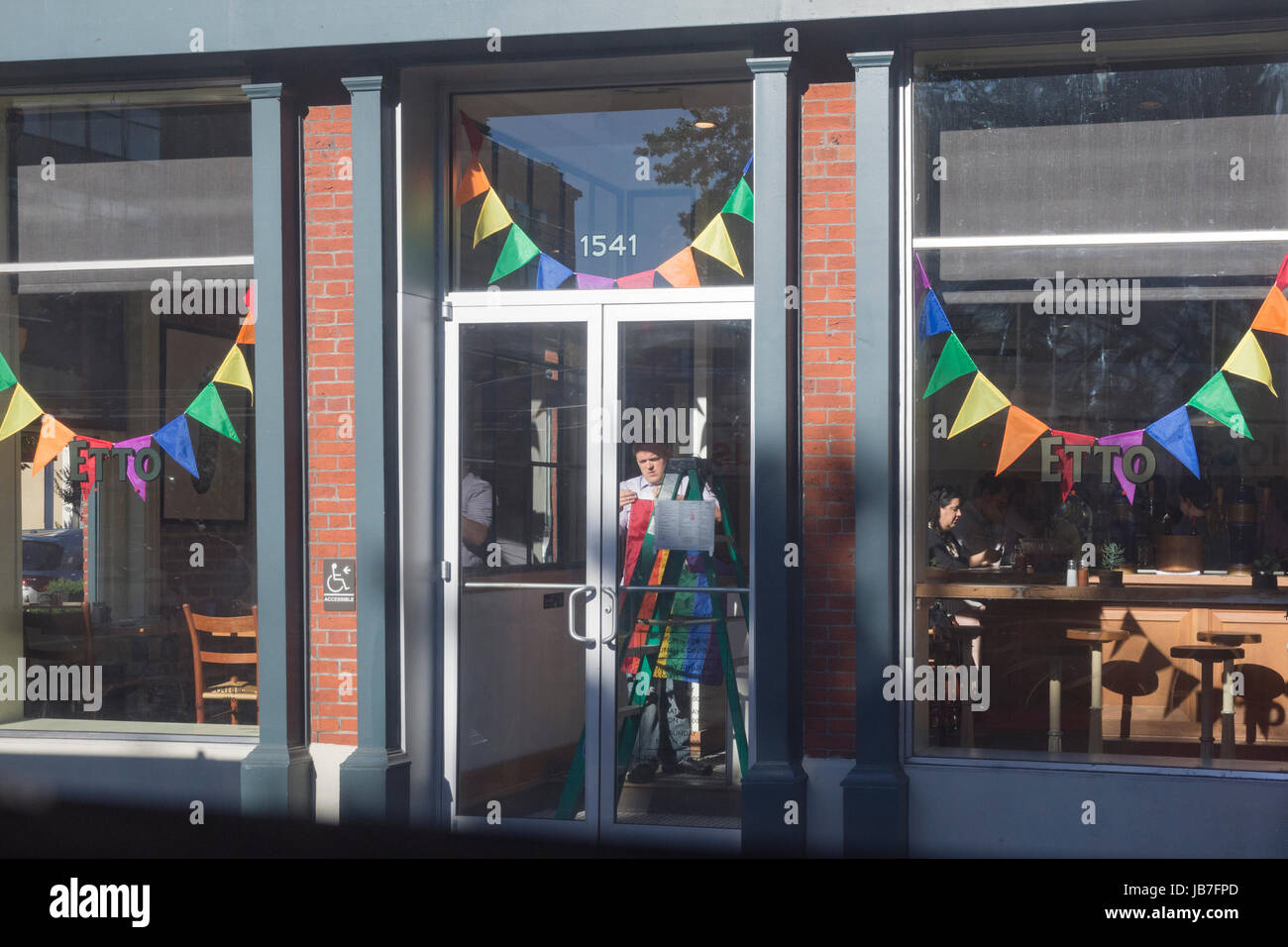 Rainbow-colored banners go up at Etto restaurant in celebration of LGBT Pride month. Stock Photo