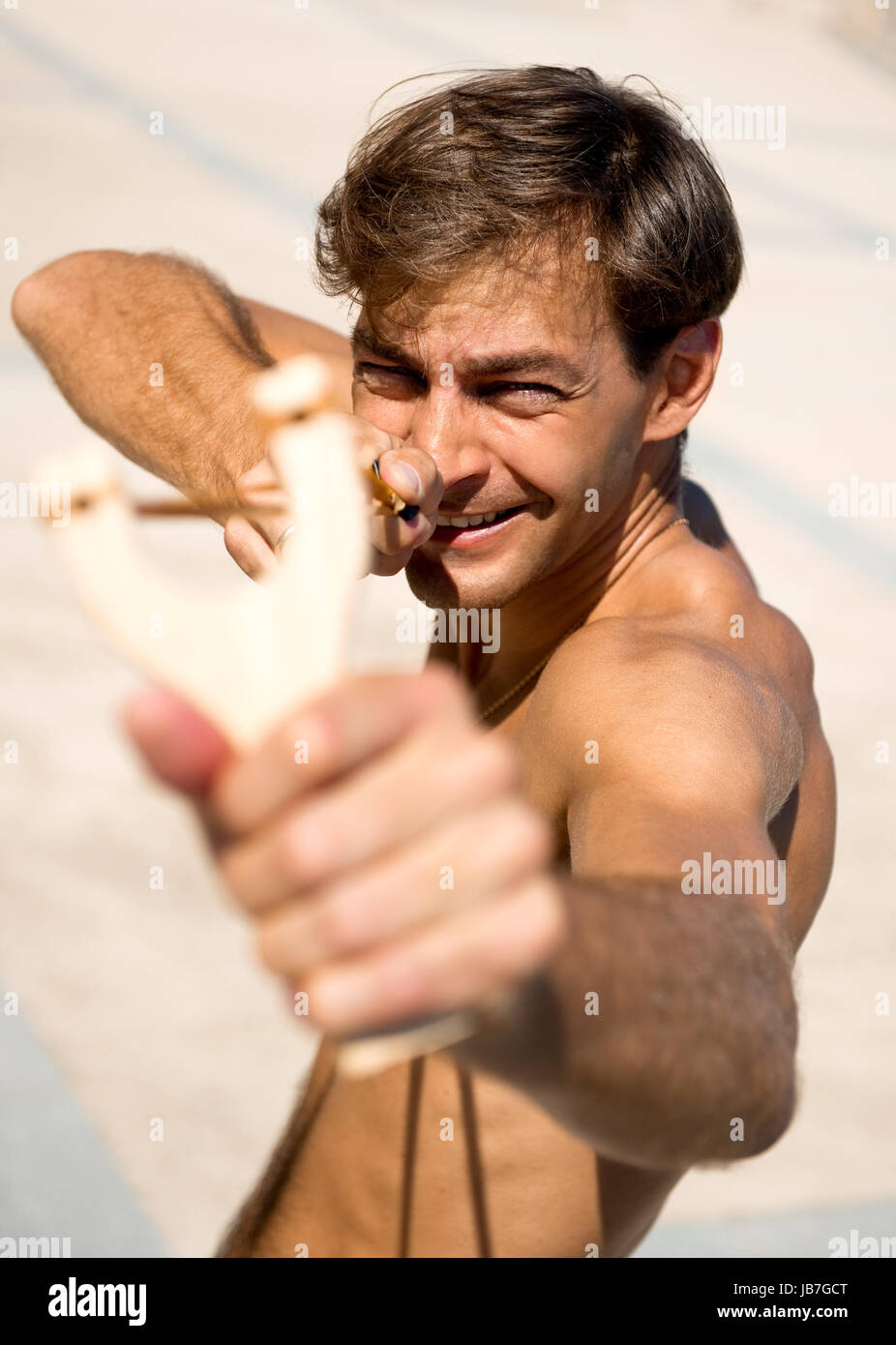 Man holding slingshot outdoors Stock Photo