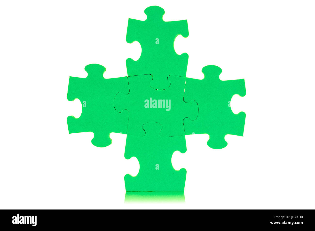 Five attached green puzzles, isolated over white background Stock Photo